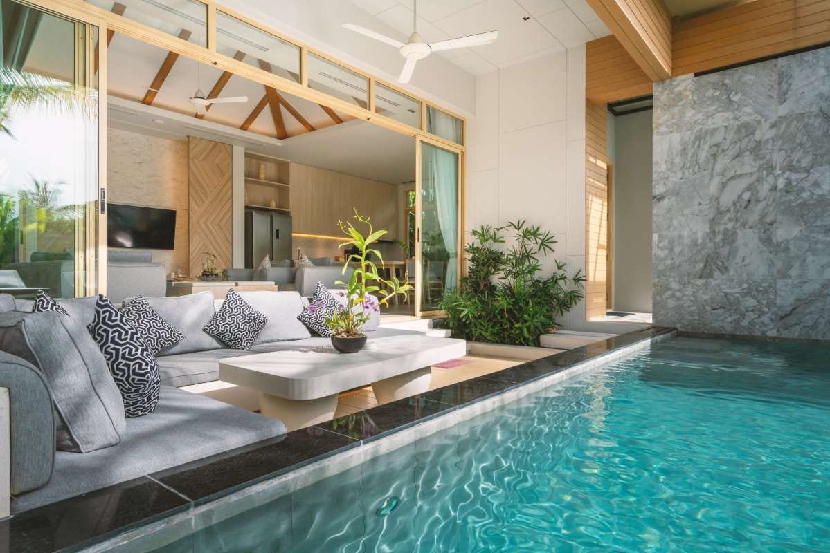 Luxury villa interior with living room opening to an indoor swimming pool