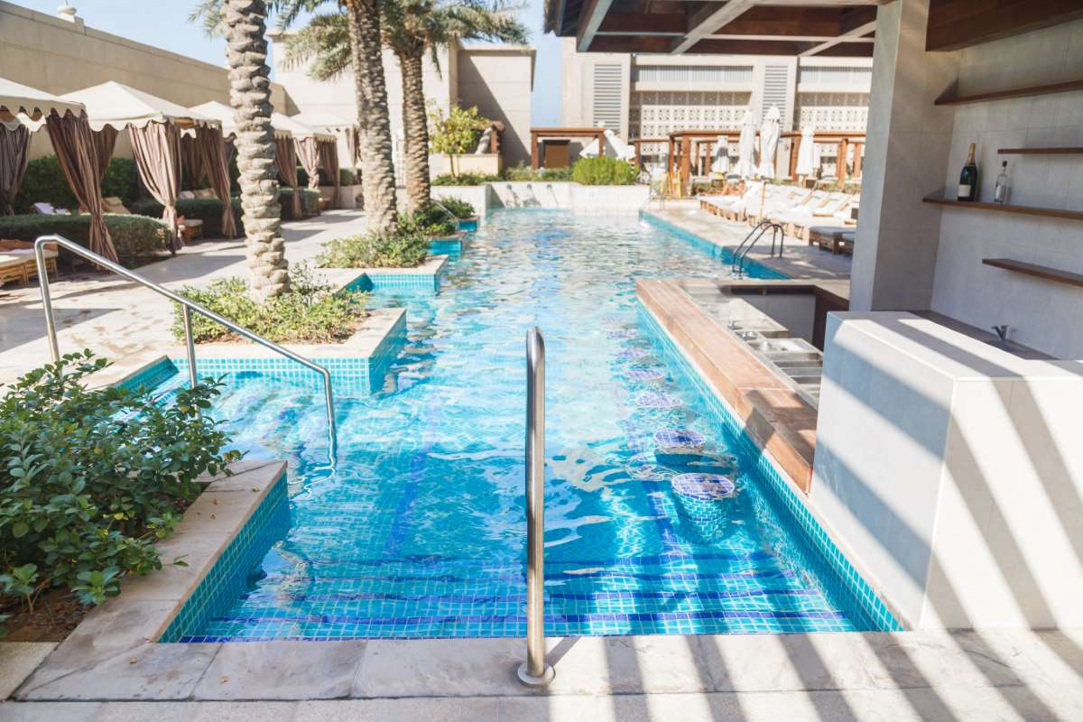 Reusing pool backwash water — close-up of crystal-clear pool water above the tile line where filter-backwash water can be reclaimed